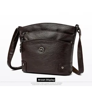 Vue détaillée du sac bandoulière marron avec trois compartiments zippés et emblème de kangourou
