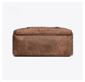 Detail view of the brown soft leather bag bottom with protective metal studs and stitching