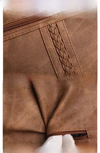 Close-up of dark brown vintage bag featuring woven straps and premium metal zipper detail