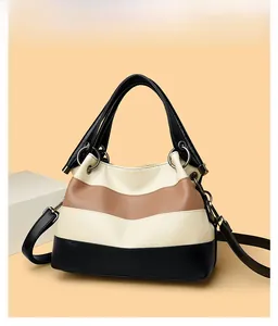Detail view of large color-block crossbody bag with pebbled leather and hardware