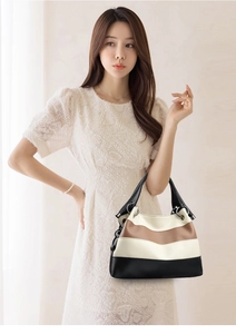 Detail of tri-color patchwork leather tote with pebbled texture and metal ring handles