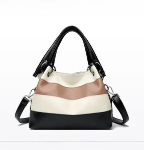 Detailed front view of three-color patchwork leather handbag with lychee texture and ring handle