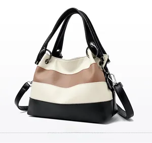 Detail view of tri-color patchwork leather handbag with litchi texture and silver hardware