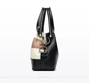 Detail view of tricolor leather handbag with lychee texture and metal ring decor