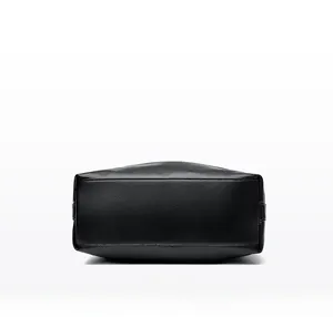 Detail view showing the reinforced rectangular bottom of the black lychee pattern leather bag
