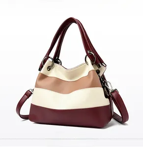 Detail of color-block tote bag featuring wine red and beige textured lychee PU leather