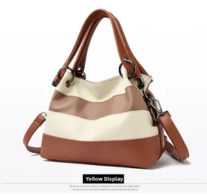Detail shot of a large tote bag featuring brown and cream stripes with lychee texture leather