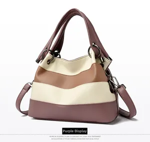 Detail of color-block striped handbag with purple, white, and brown grainy leather texture