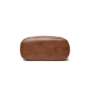 Vue du fond du sac bandoulière en cuir marron avec coutures précises et base ovale plate