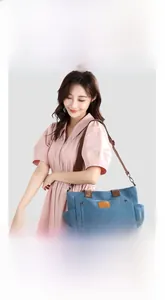 Blue canvas tote bag detail showing large front flap pocket and brown leather handles