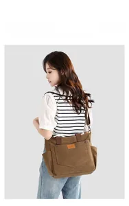 Detail of a brown canvas tote bag featuring front pockets and premium leather logo tag