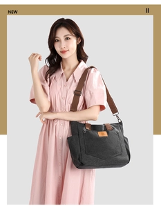 Detail view of large dark grey canvas tote bag with adjustable brown shoulder straps
