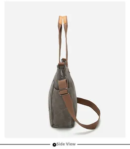 Side view of dark gray canvas tote bag featuring brown straps and functional side pocket
