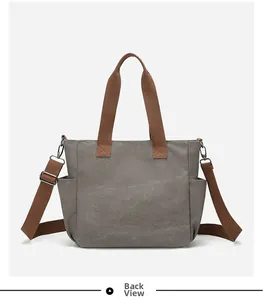 Back view of gray canvas tote bag with brown straps and side pockets details