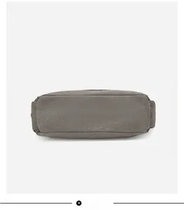 Detailed view of the wide rectangular base of this thick grey canvas handbag