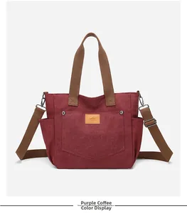 Detail of burgundy canvas tote bag featuring a brown leather logo and front pocket