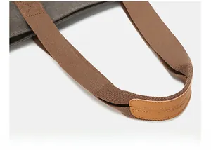 Detail of durable canvas tote handle with brown leather reinforcement and reinforced stitching