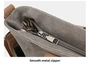 Detail of smooth metal zipper and thick grey canvas texture with striped lining