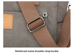 Detail showing thickened gunmetal hardware adjustment buckle on gray canvas shoulder bag