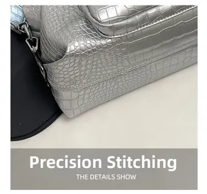 Detailed close-up showing silver crocodile texture and precise stitching on the handbag