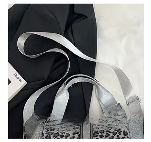 Detail of grey crocodile print and leopard fur bag with adjustable nylon strap