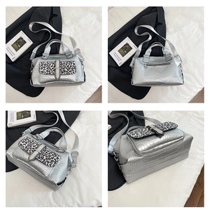 Detail of silver crocodile texture handbag with leopard print flap and metallic strap