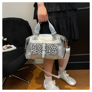 Detail of silver crocodile pattern handbag featuring a leopard print pocket and strap