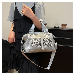 Detail of silver crocodile-embossed bag with leopard print accent and metallic hardware