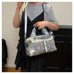 Detail of silver crocodile pattern texture and leopard print pocket on handbag