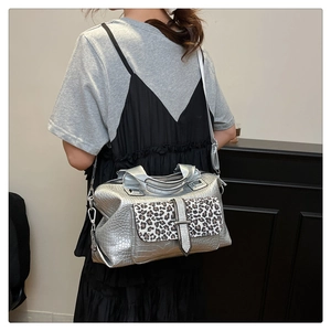 Detail of silver crocodile-embossed Boston bag with leopard print flap and metallic clasp