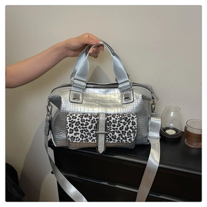 Detail of silver crocodile texture boston bag with leopard print pocket and metal handles
