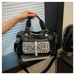 Detail of Boston bag showing leopard print flap and black crocodile texture texture