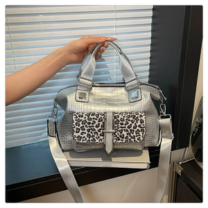 Detail of silver crocodile-embossed handbag with leopard print flap and wide strap