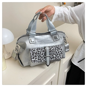 Detail of silver crocodile-embossed bag with leopard print pocket and wide strap