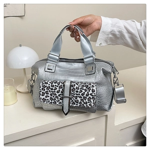 Detail of silver crocodile embossed handbag with leopard print pocket and silver hardware