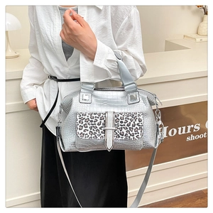 Detail of silver crocodile pattern bag with leopard print pocket and metal hardware