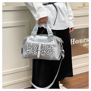 Detail of silver crocodile-embossed bag featuring leopard print pocket and chain strap