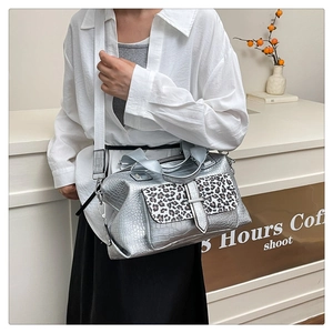 Detail of silver crocodile pattern handbag with leopard print flap and white strap