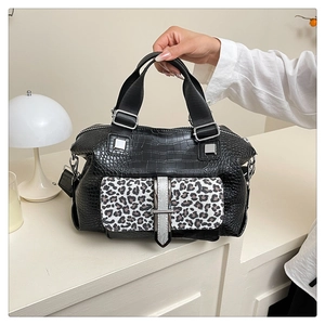 Detail of crocodile embossed handbag with leopard print flap and silver metal hardware