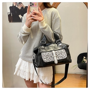 Detailed view of leopard print handbag with croc-embossed leather and metal buckle