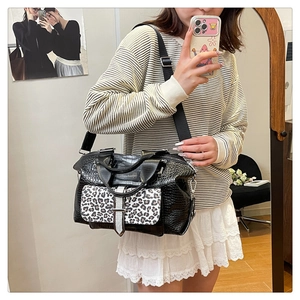 Detail of leopard print flap on black crocodile pattern leather shoulder bag