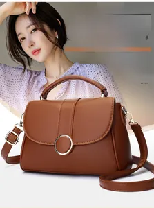 Close-up of caramel leather bag with premium gold ring clasp and sleek top handle