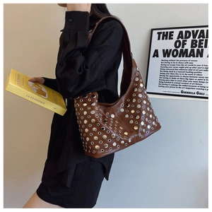 Détail d'un grand sac hobo en cuir marron orné de rivets et de clous argentés tendance