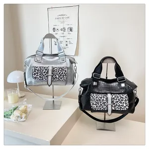 Detail view of silver and black crocodile textured tote bags with leopard print pockets