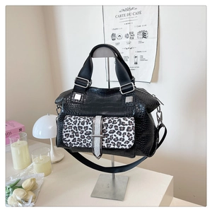 Detail of crocodile embossed leather handbag with leopard print flap and silver buckle
