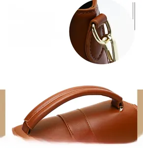 Detail of brown leather handbag featuring gold metal hardware and precision stitching