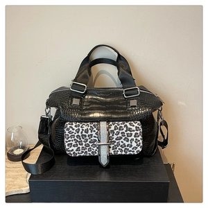 Detail of crocodile pattern handbag with leopard print pocket and wide nylon strap