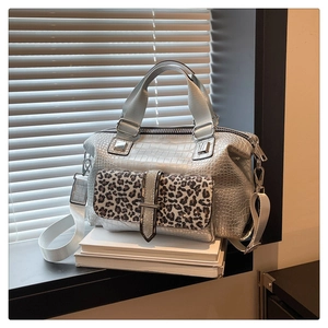Close-up of leopard print flap and silver crocodile pattern texture on the fashion handbag