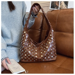 Détails du sac hobo en cuir marron foncé avec œillets métalliques et rivets argentés