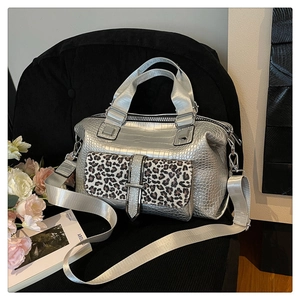 Detail of silver crocodile-embossed handbag with leopard print flap and nylon strap
